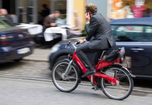 Un homme en costard au téléphone à vélo