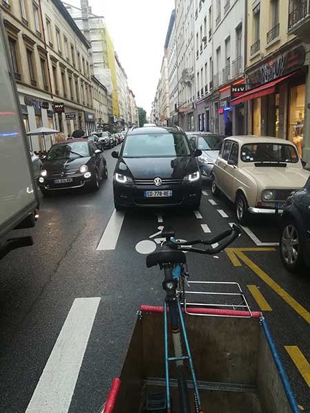 Une voiture arrive à contresens sur la voie cyclable