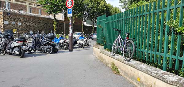 Un parking vélo rempli de deux-roues motorisées