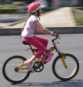 Fille sur un vélo enfant avec accessoires de sécurité