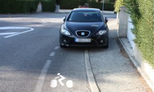 Un véhicule à l’arrêt sur la piste cyclable.