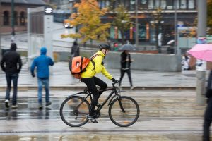 Un coursier à vélo effectuant sa livraison et qui pourra désormais profiter des avantages offerts par le syndicat des coursiers à vélo