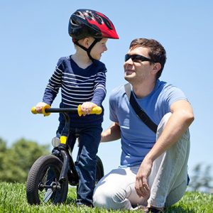 Enfant sur draisienne avec son père