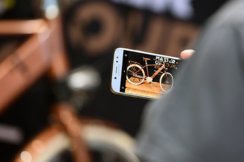 Un visiteur prend un vélo en photo avec son téléphone