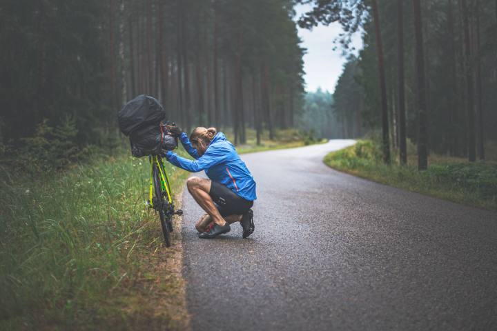 réparation en voyage à vélo par un homme qui fait du bikepacking