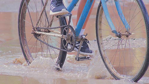 Cycliste roulant dans une flaque