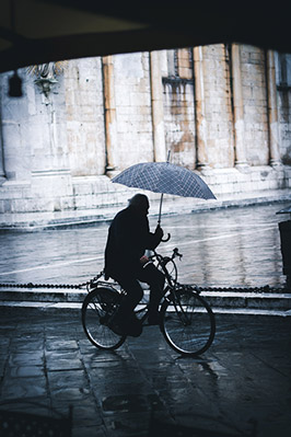 Pluie à vélo, cycliste avec un parapluie