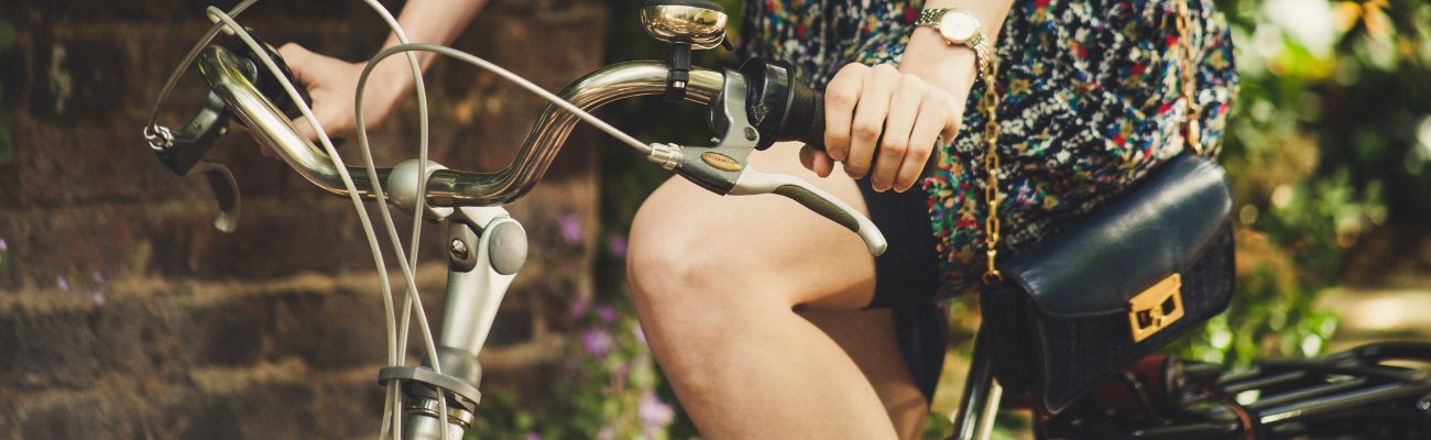 Femme faisant du vélo avec un sac à main