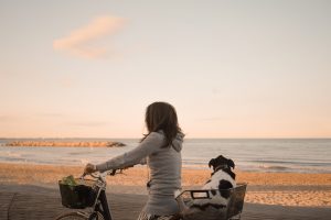 femme faisant du vélo à la plage avec son chien