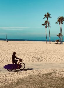 Vélo sur la plage avec une planche de surf