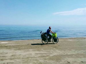 cyclotouriste devant la mer Caspienne en slow tourisme