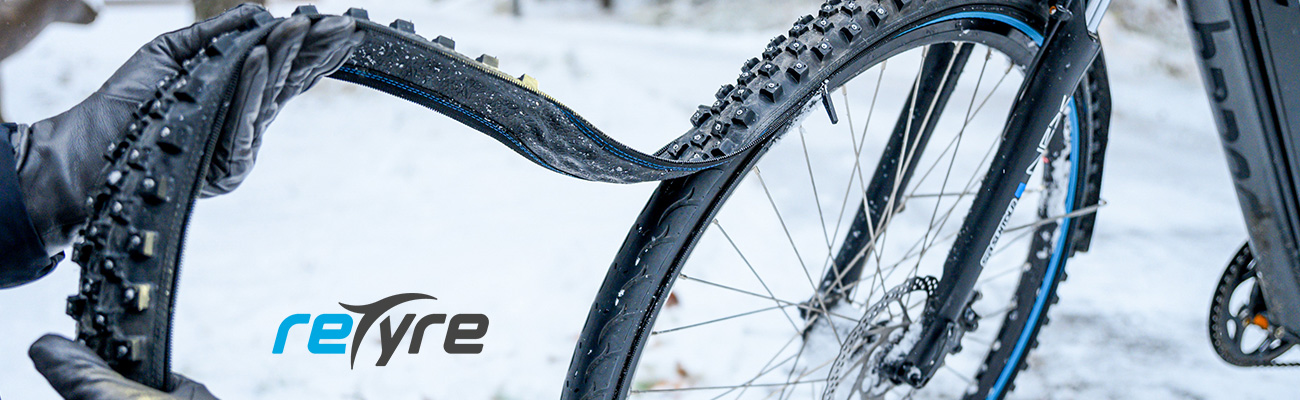 Un pneu clouté hiver dans sa sacoche vélo avec Retyre