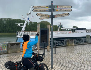 Sur son vélo, Capucine pointe du doigts les panneaux d'indication, à Macon.