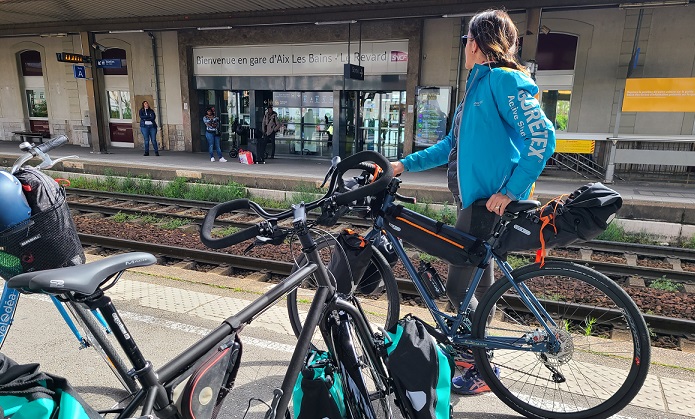 Des cyclotouristes attendent le train avec leur vélos sur le quai de la gare.