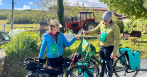 Deux cyclotouristes dégustent du vin et trinquent dans un domaine viticole.