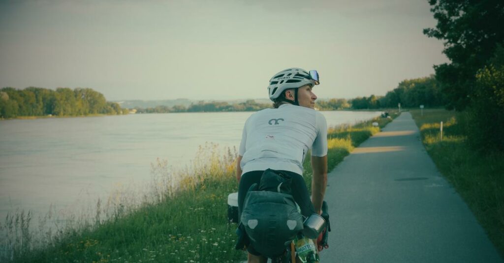 Un cycliste pédale, de dos, lors d'un voyage à vélo. 