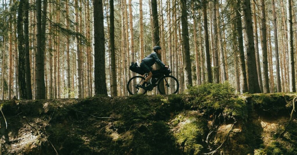 Un cycliste sur son gravel dans une forêt