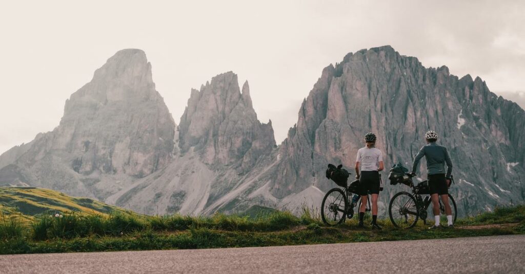 Deux cyclistes admirent le paysage, dans les Dolomites. 