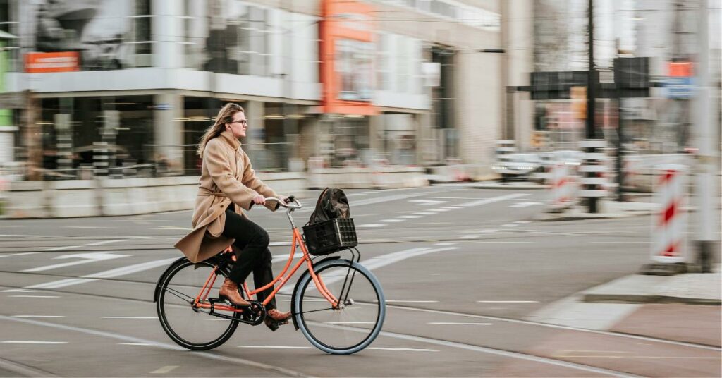 Une femme circule à vélo en ville. 