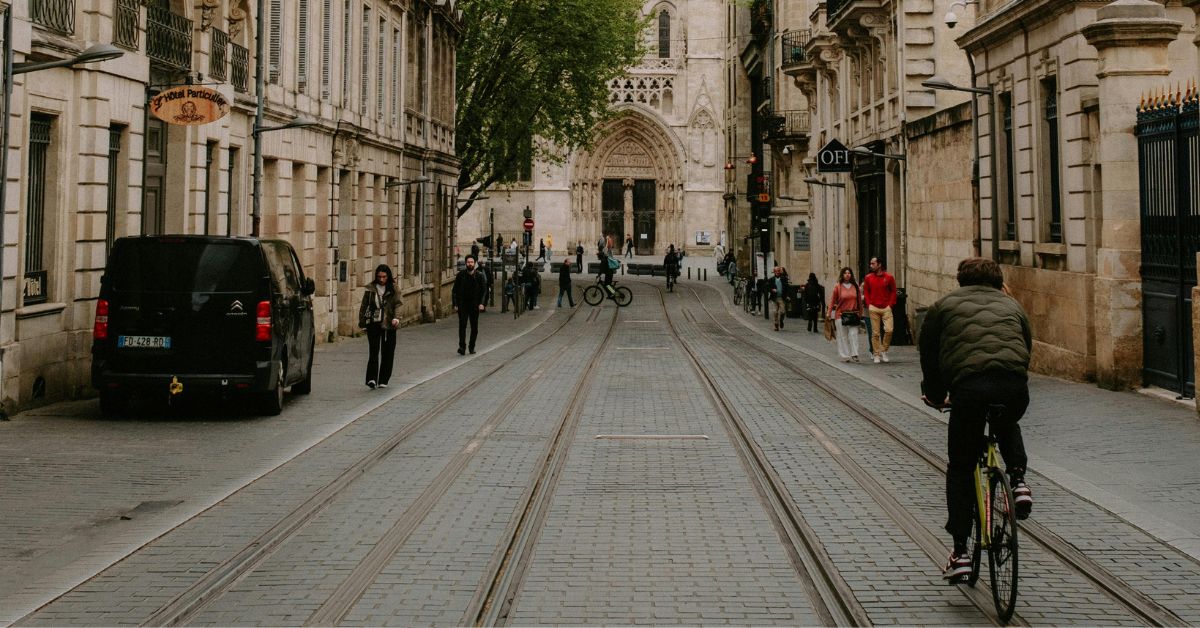 Cycliste circulant sur les rails du tramway devant la cathédrale Saint-André, illustrant les débats sur le partage de l'espace public pour les prochaines échéances locales de 2026.