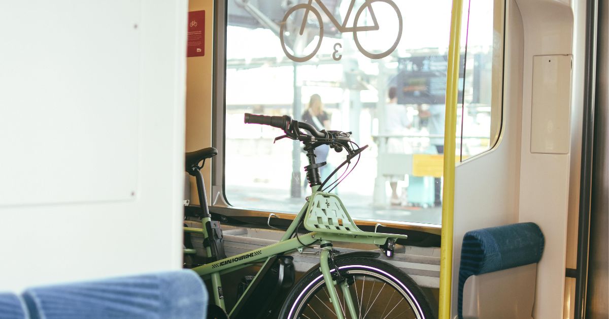 vélo électrique de type cargo stationné dans un wagon de train, symbolisant le défi de l'intermodalité et du transport longue distance pour les politiques urbaines de 2026.