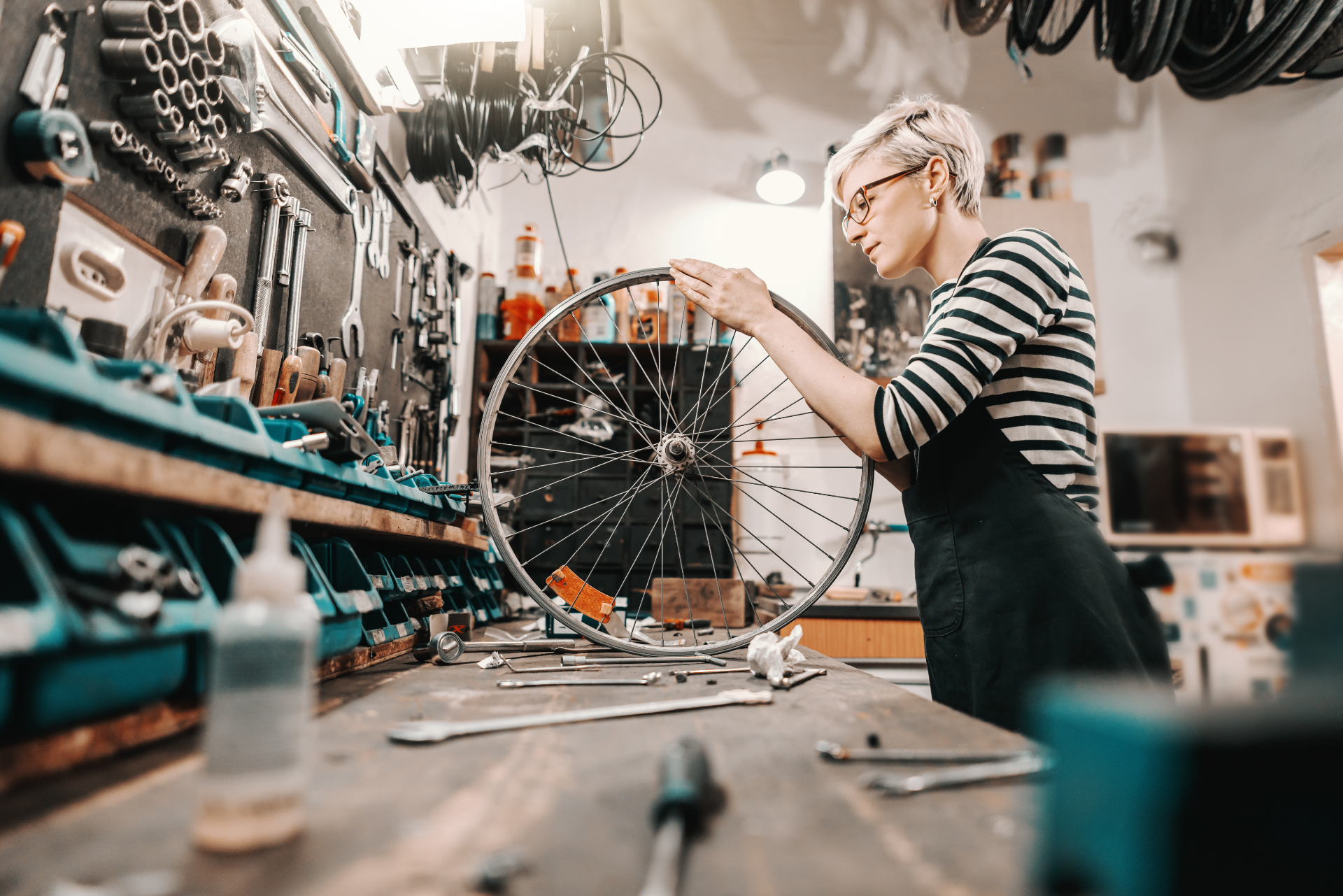 femme en train de réparer une roue de vélo d'occasion dans un atelier