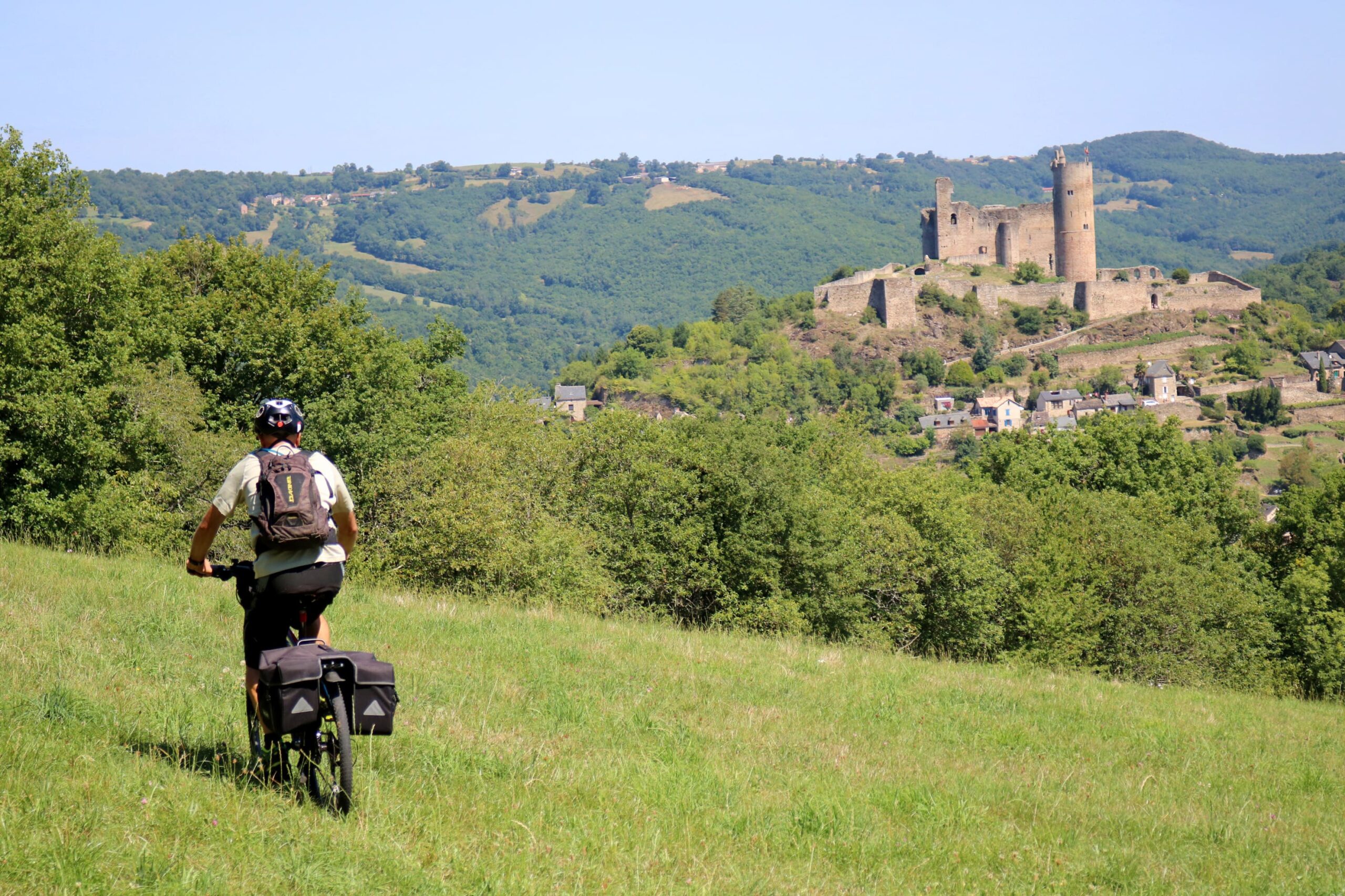 cycliste qui roule sur l'herbe, avec un château en arrière plan