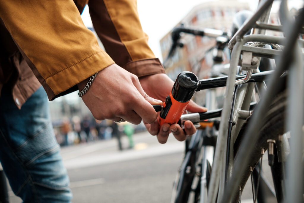 une personne accroche un antivol à son vélo en ville