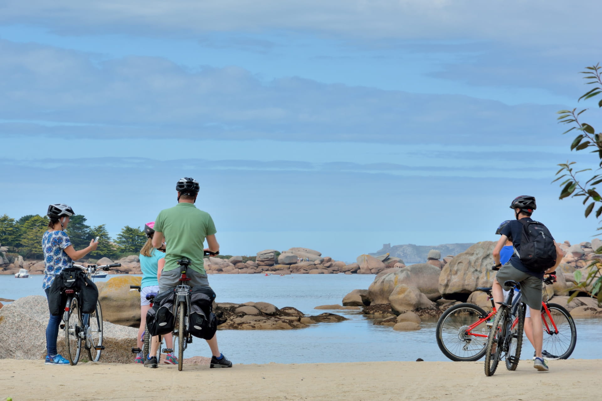 Une famille à vélo en Bretagne arrêtée devant la mer