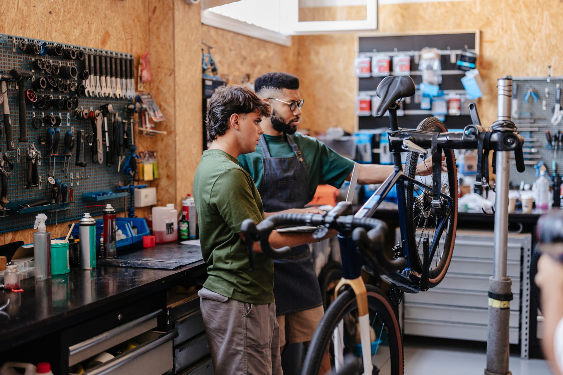 deux hommes réparent un vélo dans un atelier