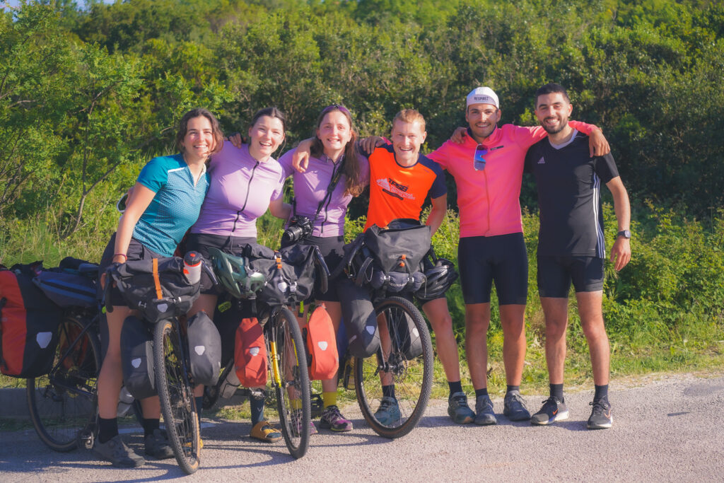 6 cyclistes qui posent tous sourires avec leurs vélos