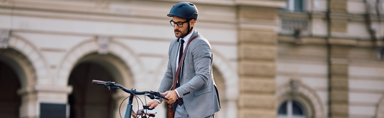 homme avec un casque avec son vélo en ville