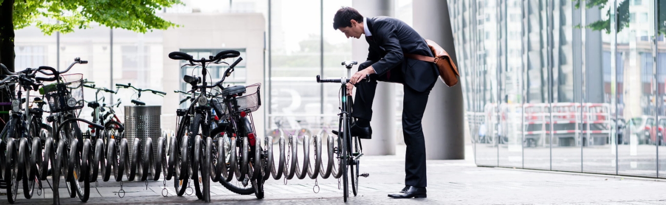 Homme urbain accrochant son vélo dans un parking à vélo