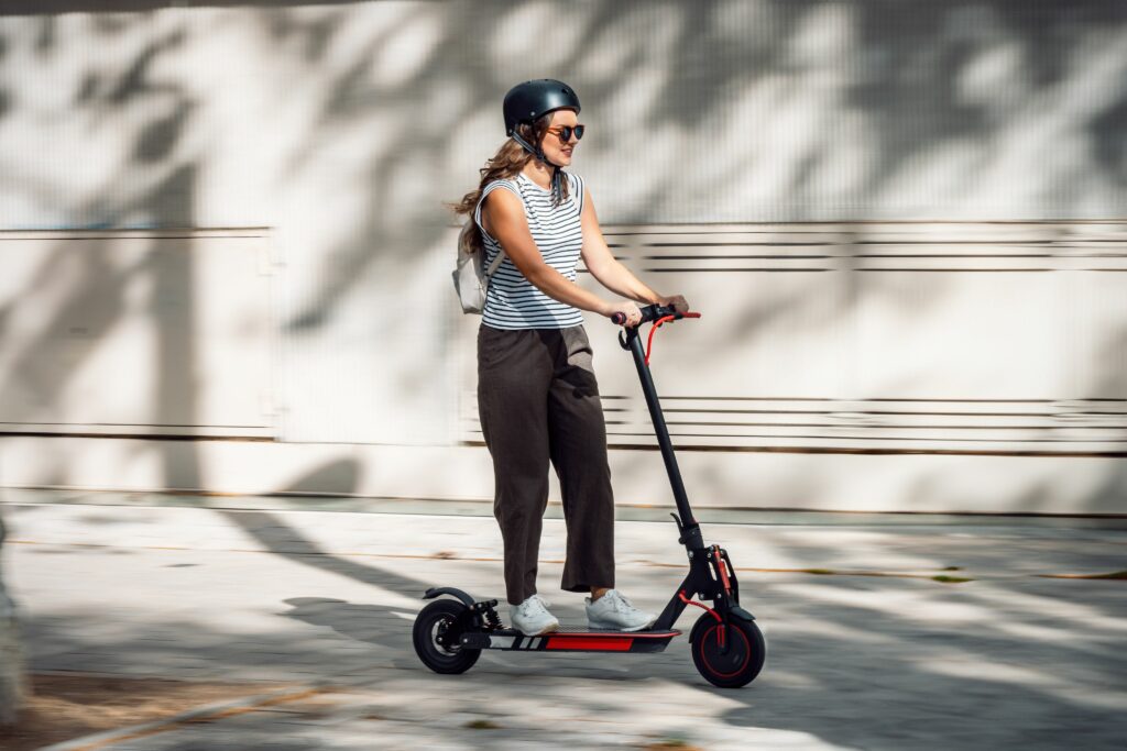 Femme sur une trottinette électrique avec un casque en ville