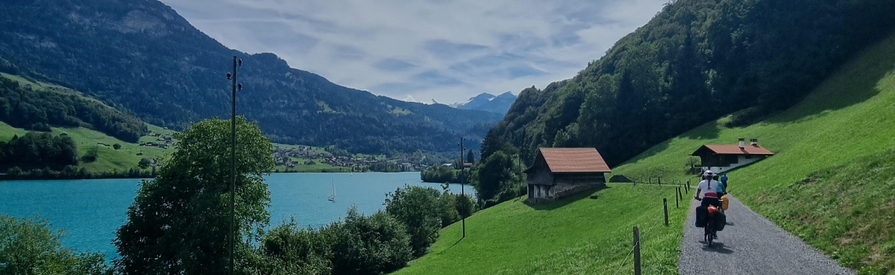 paysage lacs et montagnes suisse avec cyclotouriste sur chemin gravel