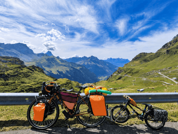 Vélo adulte chargé de sacoches tractant un vélo enfant via le système Follow-Me