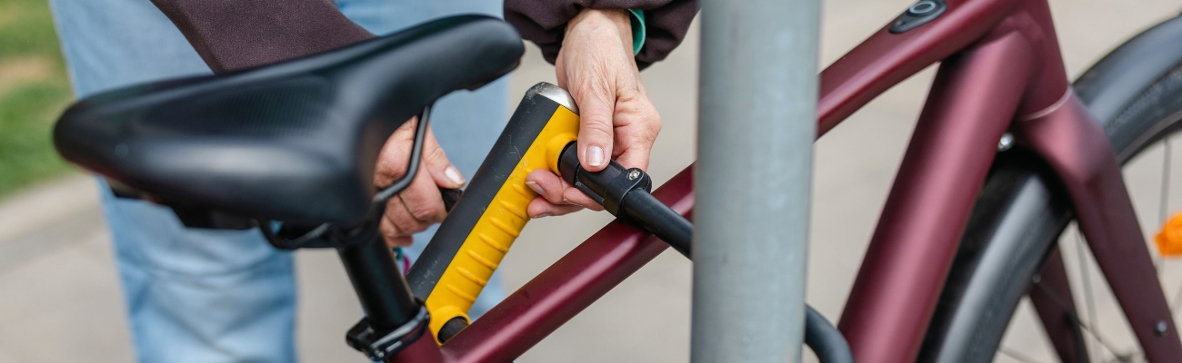 femme qui accroche un antivol vélo en U à son cadre de vélo
