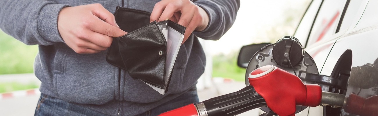 Essence à plus de 2 euros homme à la pompe à essence avec un portefeuille à la main